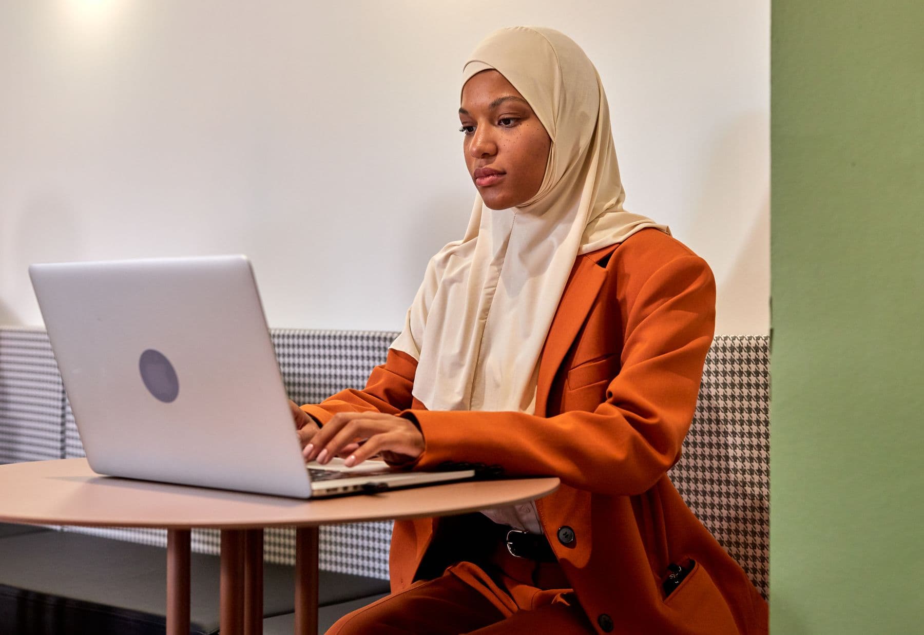 A woman working on a laptop in an office